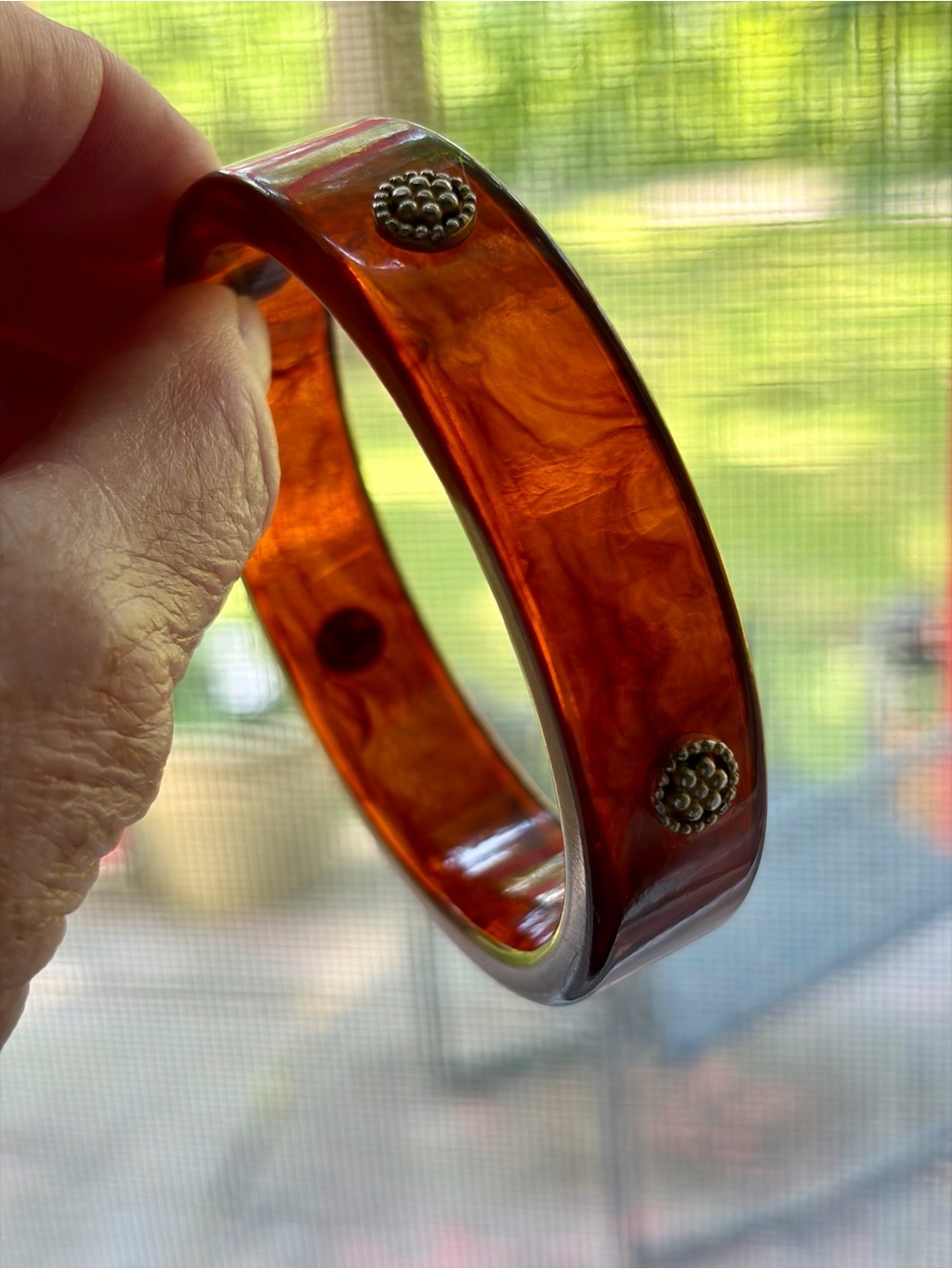 rootbeer-colored bakelite bangle features distinctive metal studs. 7.5"